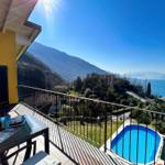 Terrasse mit Pool und Blick auf See und Berge.