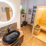 Badezimmer mit Sauna, Waschtisch und Toilette.