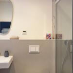 Badezimmer mit Dusche, Waschbecken und Spiegel.