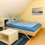 Schlafzimmer mit Bett, Nachttischen und Wandbild.