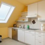 Küche mit Dachfenster, Spüle, Kaffeemaschine und Geschirrspüler.