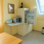 Küche mit Kühlschrank, Mikrowelle und Tisch.