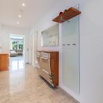 Flur mit Garderobe, Spiegel und Blick in Wohnbereich.