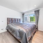 Schlafzimmer mit Bett, Fenster und Holzboden.