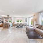 Offener Wohn- und Essbereich mit Küche und großem Fenster. Modern eingerichtet.