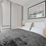 Bedroom with bed, wardrobe, and wall art.