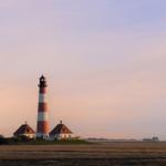 Lighthouse with red and white stripes on an island.