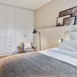 Bedroom with bed, wardrobe, and armchair.