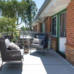 Terrace with two chairs and view of green trees.