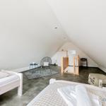 Zwei Betten, Sitzgelegenheit und Babybett in Dachschrägenzimmer