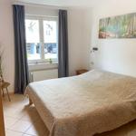 Schlafzimmer mit Bett, Fenster und Wandbild.