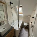 Badezimmer mit Badewanne, Dusche, WC und Waschbecken.