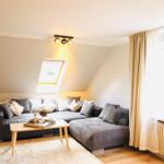 Wohnzimmer mit grauem Sofa, Holztisch und Dachfenster.