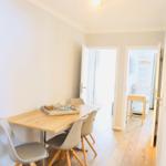 Essbereich mit Holztisch und Stühlen, helle Wände und Holzfußboden.