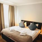 Schlafzimmer mit Bett, Vorhängen und Nachttisch mit Lampe.