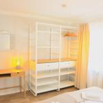 Schlafzimmer mit Schreibtisch, Kleiderschrank und Bett.