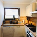 Küche mit Arbeitsplatte, Spüle, Herd und Fenster