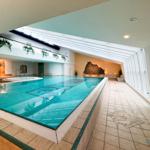 Innenpool mit Whirlpool und Dachfenster. Fliesenboden und Wanddekoration.