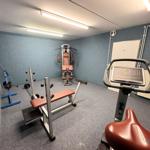 Fitnessraum mit Geräten für Kraft- und Kardiotraining.