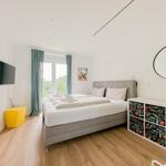 Schlafzimmer mit Bett, TV und Fenster mit Blick auf Garten.