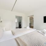 Zwei Betten mit karierten Bettwäsche, Spiegel und Fernseher an der Wand.