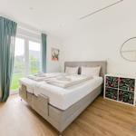 Schlafzimmer mit Doppelbett, Fenster, Schrank und Spiegel.