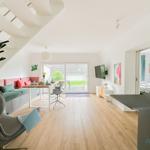 Wohnbereich mit Essbereich, Schlafzimmer und Küche. Holzboden und große Fenster.