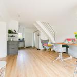 Wohn- und Essbereich mit Treppe, Stuhl und Esstisch.