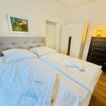 Schlafzimmer mit Doppelbett, Kleiderschrank und Nachttisch mit Lampe.