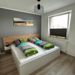Schlafzimmer mit Doppelbett, Holzfußboden und Fenster mit Blick.