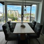 Esszimmer mit Tisch und Stühlen, Blick auf Balkon und Stadt.