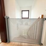 Child safety gate at staircase with window in background