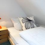 Bedroom with bed, nightstand, and lamp under sloped ceiling