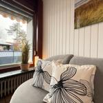 A gray seating area with cushions by a window overlooking a garden.