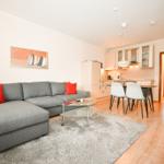 Wohnzimmer mit Sofa, Couchtisch und angrenzender Küche.