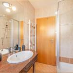 Bad mit Dusche, Waschbecken und Heizkörper