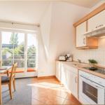 Küche mit Esstisch, Balkon und Küchengeräten.