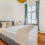 Schlafzimmer mit Doppelbett, Fenster, Vorhängen und Wandbild.