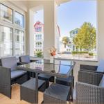 Terrasse mit Sitzgruppe und Tisch. Blick auf Gebäude und Bäume.