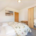 Schlafzimmer mit Bett, Kleiderschrank und Wandbild.