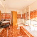 Badezimmer mit Dusche, Badewanne und Waschtisch mit Spiegel