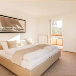 Schlafzimmer mit Doppelbett, Fernseher und Fenster zur Aussicht.