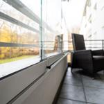 Terrasse mit Sitzgelegenheit und Blick auf einen Park.