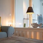 Ein Raum mit Sofa, Lampe und Fischdekoration an Fensterbank