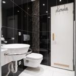 Dusche mit Duschwanne, Toilette und Waschbecken mit modernem Design.