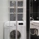 Waschmaschine im Bad mit Dusche und Waschbecken.