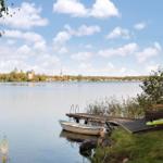 Boot liegt am Steg. Blick auf Wasser und Stadt mit Kirchen.