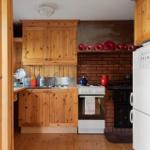 Küche mit Holzschränken, Backofen und Kühlschrank.