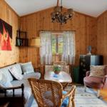 Wohnzimmer mit Holzwand, Sofa, Stuhl und Tisch