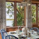 Esszimmer mit Tisch, Stühlen und Blick auf See